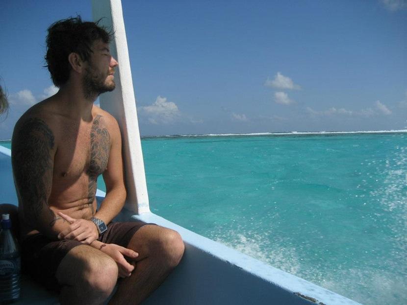 Mandlig rejsende beundrer det turkisblå hav i Belize Det varme, klare vand i Belize