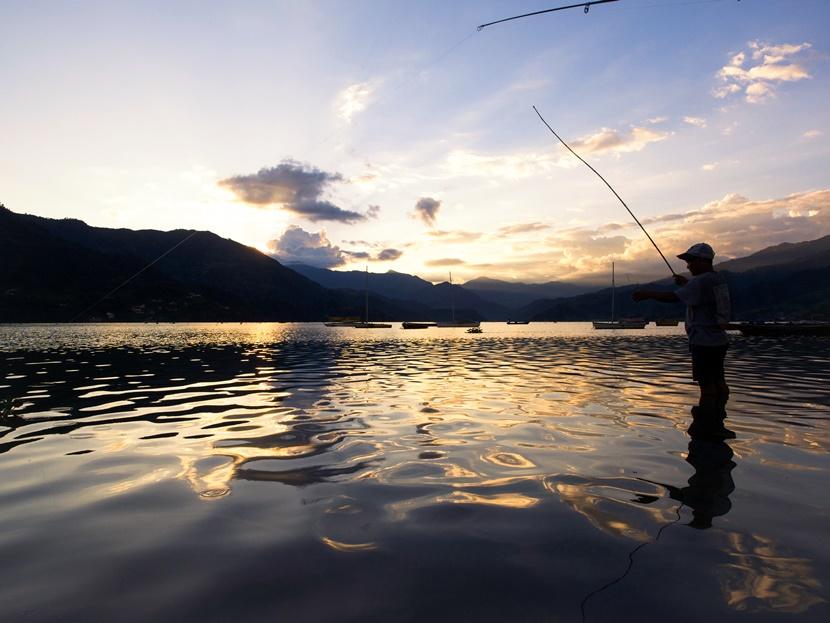 Un pescatore sul lago al tramonto Pescatore lago fewa