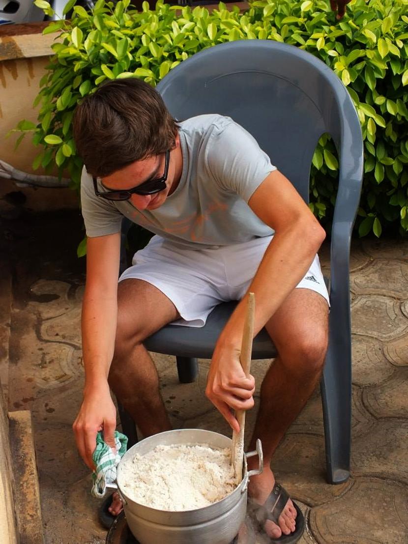 un volontario in azione durante il corso di cucina in Togo Uno dei volontari alle prese con la preparazione della salsa djenkoumé