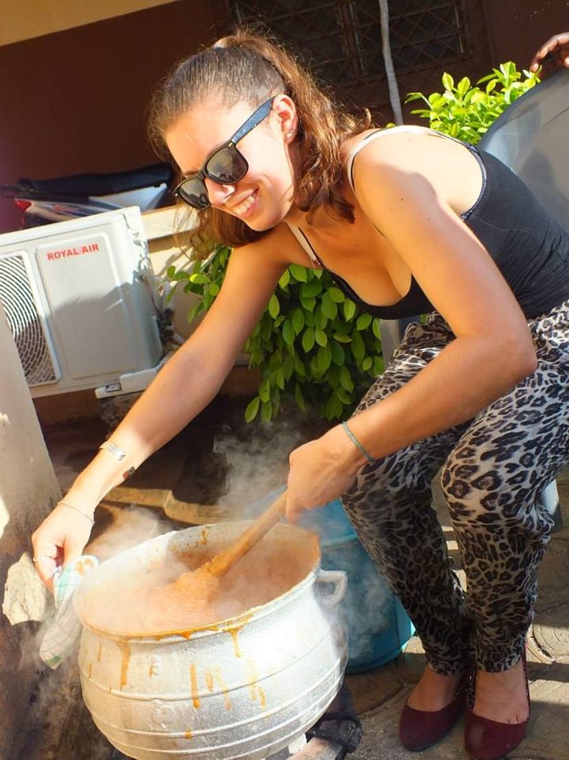 Corso di cucina togolese: una volontaria all’opera Una volontaria alle prese con la preparazione della salsa
