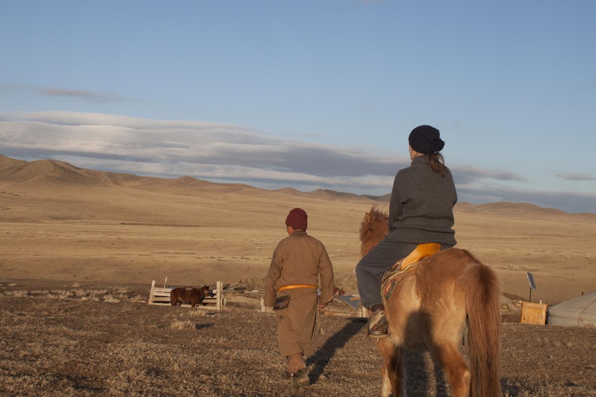 Una volontaria senior in sella ad un cavallo in Mongolia Una volontaria Over 50 nel progetto con i Nomadi in Mongolia in sella ad un cavallo