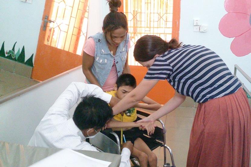 Een fysiotherapie vrijwilliger verzorgt een kind in Cambodja Vrijwilligerswerk Cambodja medisch project