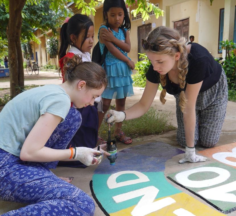 Vrijwilligers van de Sociaal & Samenleving jongerenreis naar Cambodja zijn druk bezig met het schilderen van het schoolplein. Het schoolplein wordt door vrijwilligers van de Sociaal & Samenleving jongerenreis naar Cambodja voorzien van educatieve schilderingen.