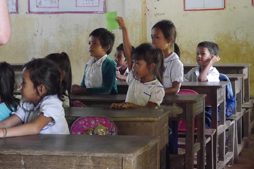 De kinderen op een school in Cambodja krijgen les van de vrijwilligers van de jongerenreis. Schoolkinderen in Cambodja kunnen de vrijwilligers van de jongerenreis alle vragen stellen die ze hebben.