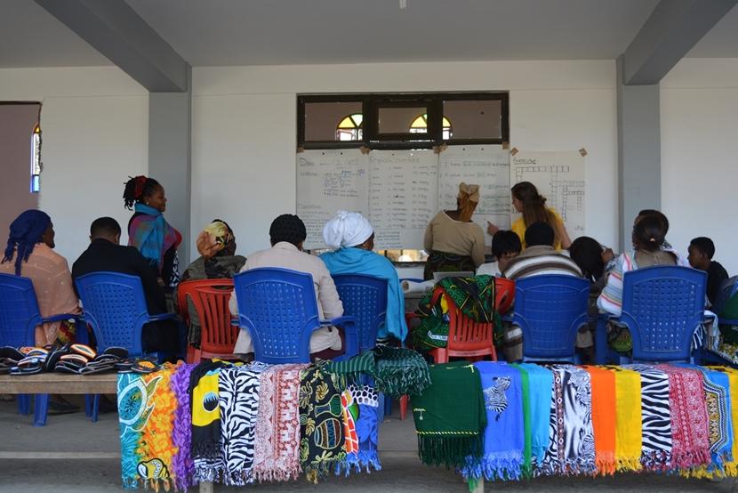 Vrouwen van het microkrediet project in Tanzania letten goed op tijdens de training van een vrijwilliger. De vrouwen die een lening hebben ontvangen, krijgen training van een vrijwilliger.