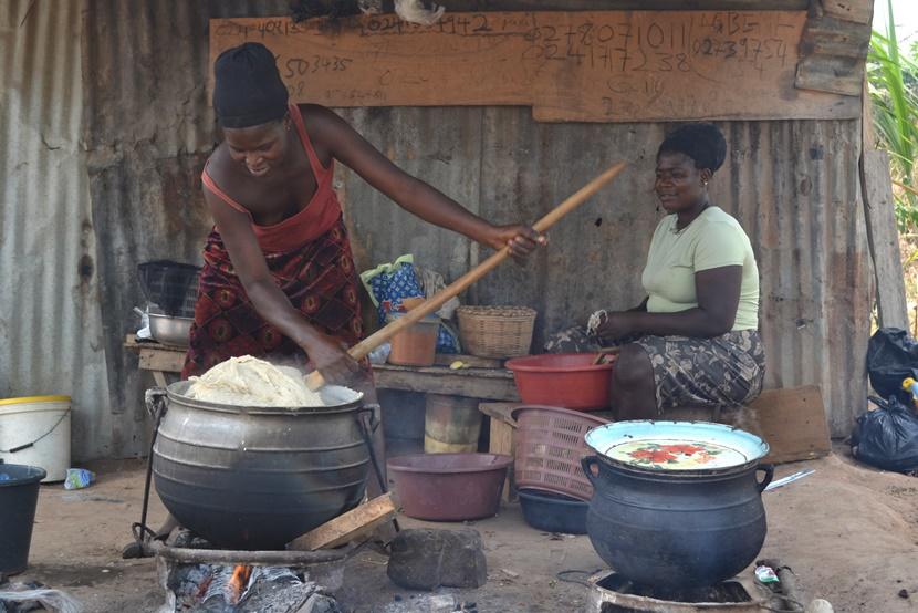 Two women prepare food outside Two women prepare food