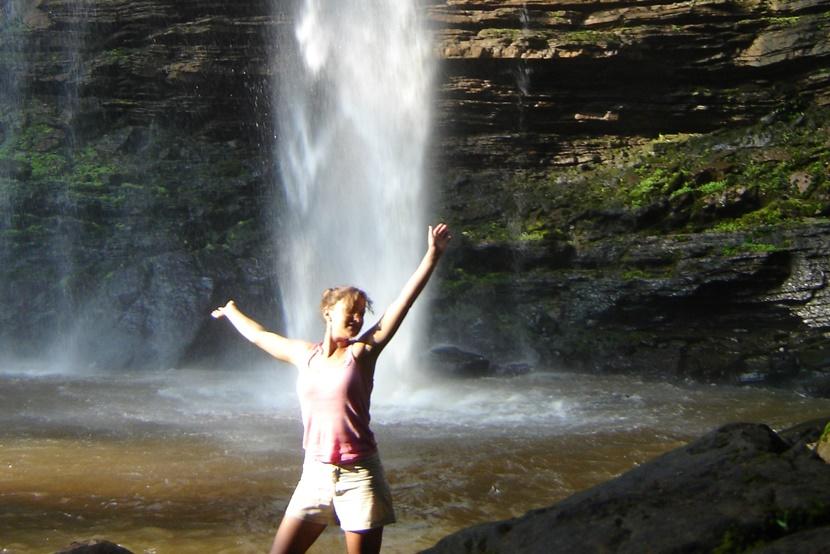 A volunteer visiting Wli Falls A girl standing in front of waterfall