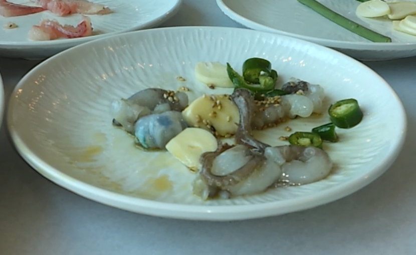 Live squid squirming on a plate A plate of live squid