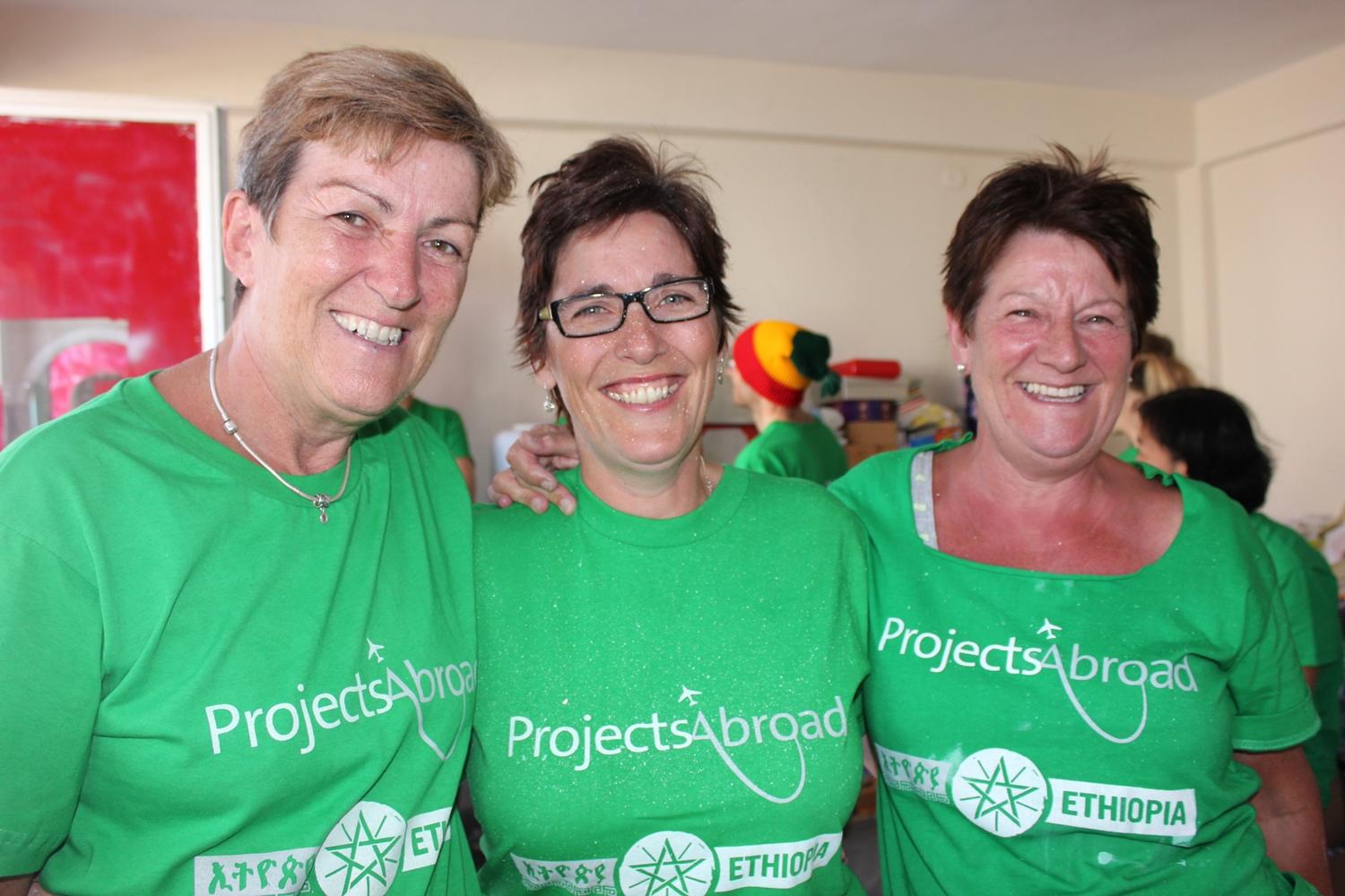A group of older adults volunteering abroad take a break between activities in Ethiopia. Older adults volunteering in Ethiopia with Projects Abroad take a photograph together at their placement.