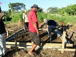 Volontaire aidant à bâtir les fondations de la future maison. humanitaire aux Fidji