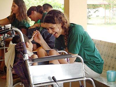 A volunteer feeds a physiotherapy patient in Cambodia Physiotherapy can drastically improve children’s quality of life