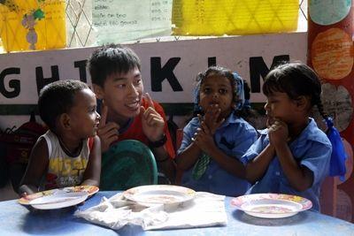 A volunteer at a Care project in Sri Lanka talks to children before their meal Projects Abroad Care volunteer, Herman Chi Hong Chan, with children at his placement at Dutch Anne Preschool in Panadura.