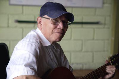 Elderly man plays guitar One of the seniors at Asociacion Centro de Atención al Anciano Francisca Valerio Badilla strums the guitar