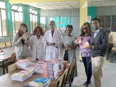 The Director of Berhane Zare School stands with newly donated books for his students Projects Abroad staff and volunteers present a donation of academic and fictional books to the Director of Berhane Zare School in Addis Ababa, Ethiopia