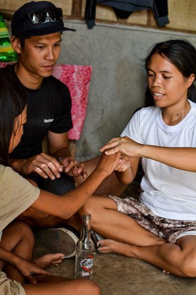 A volunteer teaching a patient's mother how to do physio exercises A volunteer teaching a patient's mother how to do physio exercises