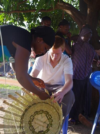 A Togolese artisan shows an International Development volunteer how to weave A craftperson in Togo shows an International Development volunteer how to weave a basket