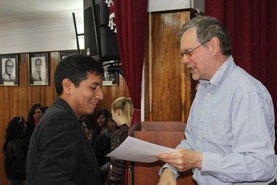 Local teacher receiving his certificate signed by the Regional Director of Education in Peru saying he completed the Teacher Training Teaching volunteer handing a certificate to a local teacher who attended the training sessions