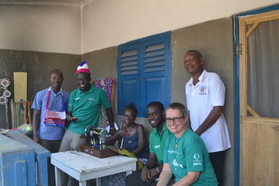 Micro-finance volunteers posing with a handicraft shop in the leprosy camp Volunteers and staff with Victoria who owns a handicraft shop