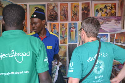 James, an art shop owner, showing the Micro-finance volunteer and staff his work Leprosy community member showing a volunteer his shop