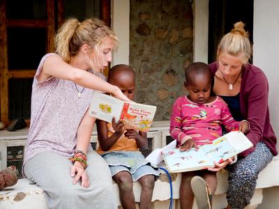 Volunteers read to children on a Care placement Volunteers sit with children