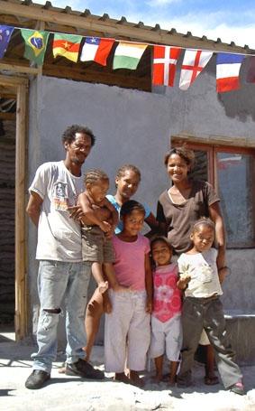 Familie, die sich für ihr Township einsetzte, vor der Tagesstätte sudafrika-hausbau-township-familie