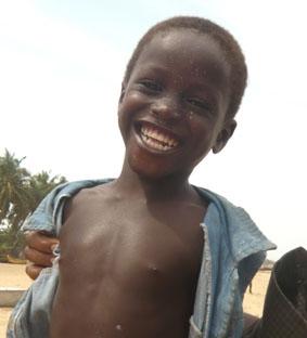Ein strahlender Fischerjunge am Strand in Aflao (Grenzstadt zu Togo) ghana-medizin-fischerjunge