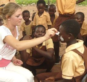 Arbeit an einer Schule: beim Versorgen von Hitzeausschlägen der Kinder im Gesicht ghana-medizin-schulprojekt