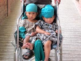 Kinder mit grünen Hauben warten auf ihre OP Nepal, Physiotherapie, Operation