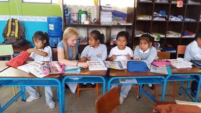A volunteer working with young school children A volunteer working with young school children