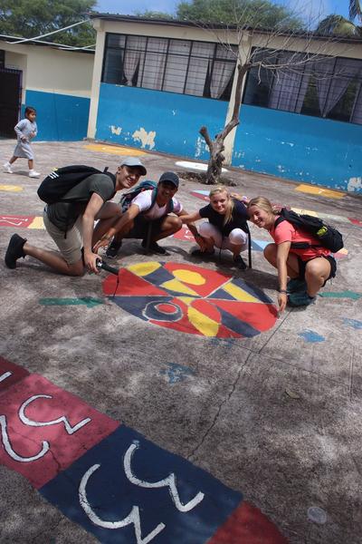 Volunteers posing next to the mural they painted Volunteers posing next to the mural they painted