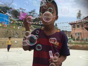 Young boy blowing bubbles at the care centre Young boy blowing bubbles at the care centre
